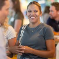 Woman smiling at two people standing in conversation